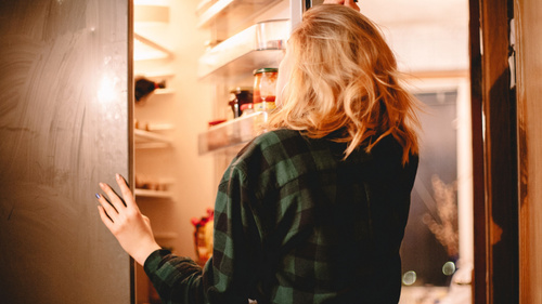 Frau nachts am Kühlschrank