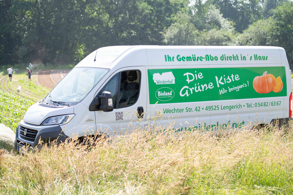 KI generiert: Ein Lieferwagen mit der Aufschrift: "Ihr Gemüse-Abo direkt in's Haus. Die Grüne Kiste - Wir bringen’s!"