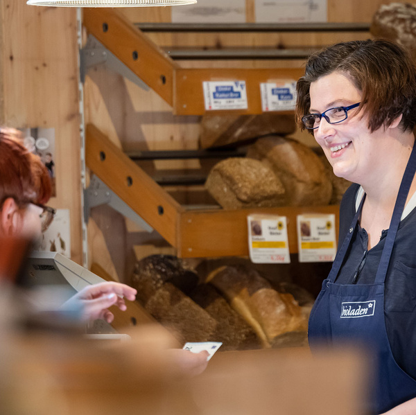 KI generiert: Eine Verkäuferin bedient einen Kunden in einer Bäckerei.