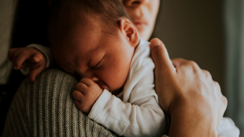 Baby schläft auf Arm