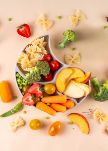 Eine runde Schale gefüllt mit frischem Obst, Gemüse und Nudeln auf einem hellen Hintergrund.