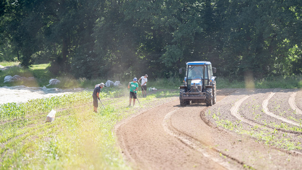 KI generiert: Menschen und Traktor auf einem Feld bei der Landwirtschaft im Einsatz.