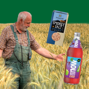 Ein älterer Mann in einem Feld mit Produkten: "Smokey Salt" und "bio sprizz cassis lime".