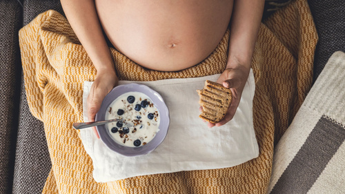 Schwangere Frau mit Müsli