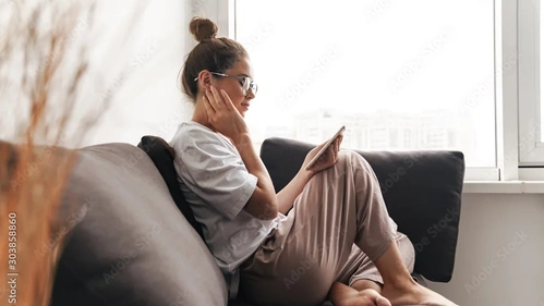 Frau mit Handy auf dem Sofa